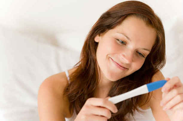 woman smiling after taking pregnancy test