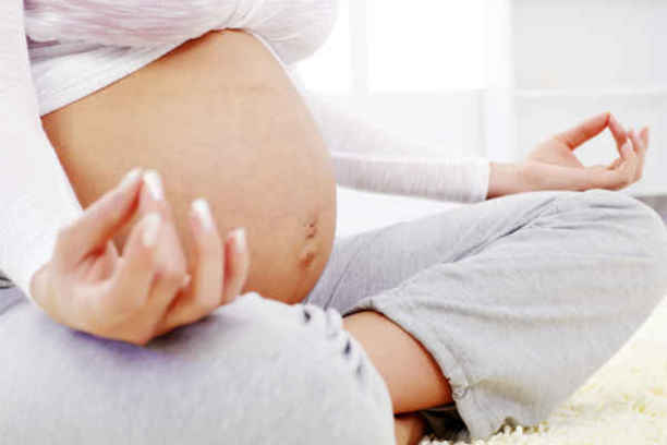pregnant woman with belly showing meditating