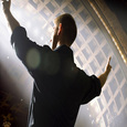 man lifting both hands in the air while speaking at a conference