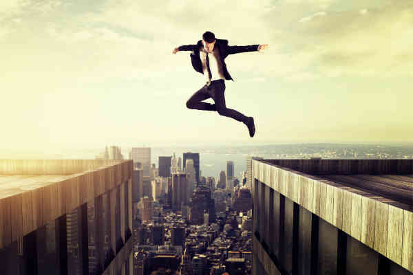 man jumping over buildings