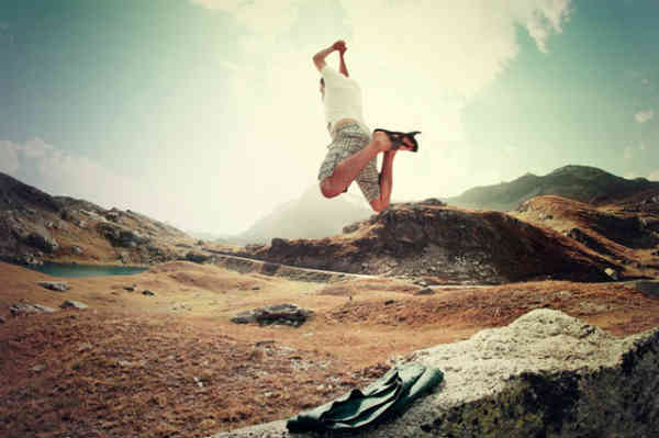 man jumping on a mountain confidently
