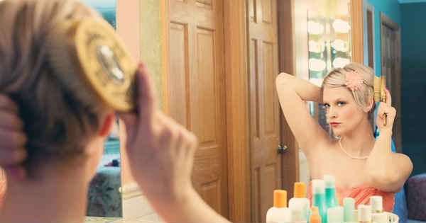 pretty woman in front of a mirror doing makeup