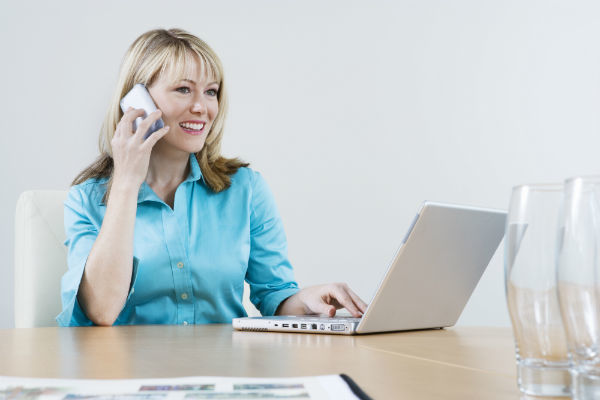 secretary talking on phone and using laptop