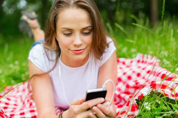 woman listening to affirmations in the park