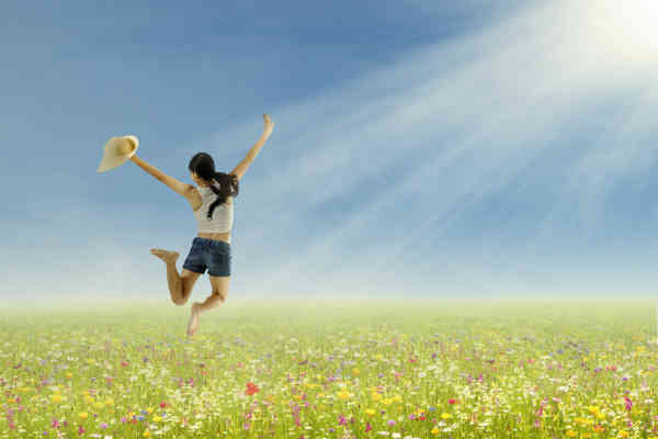 woman full of joy jumping in the field