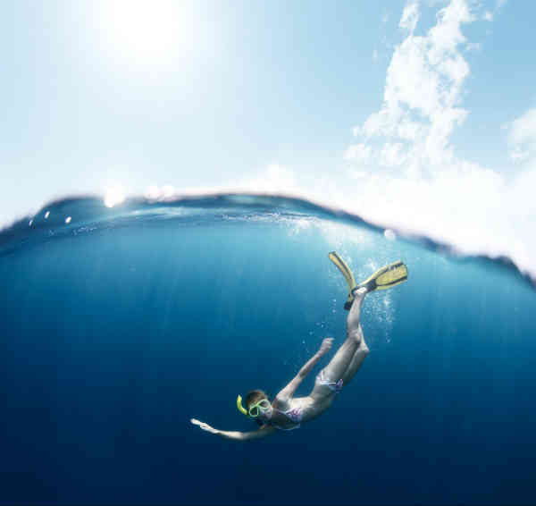 woman swimming and diving in an ocean
